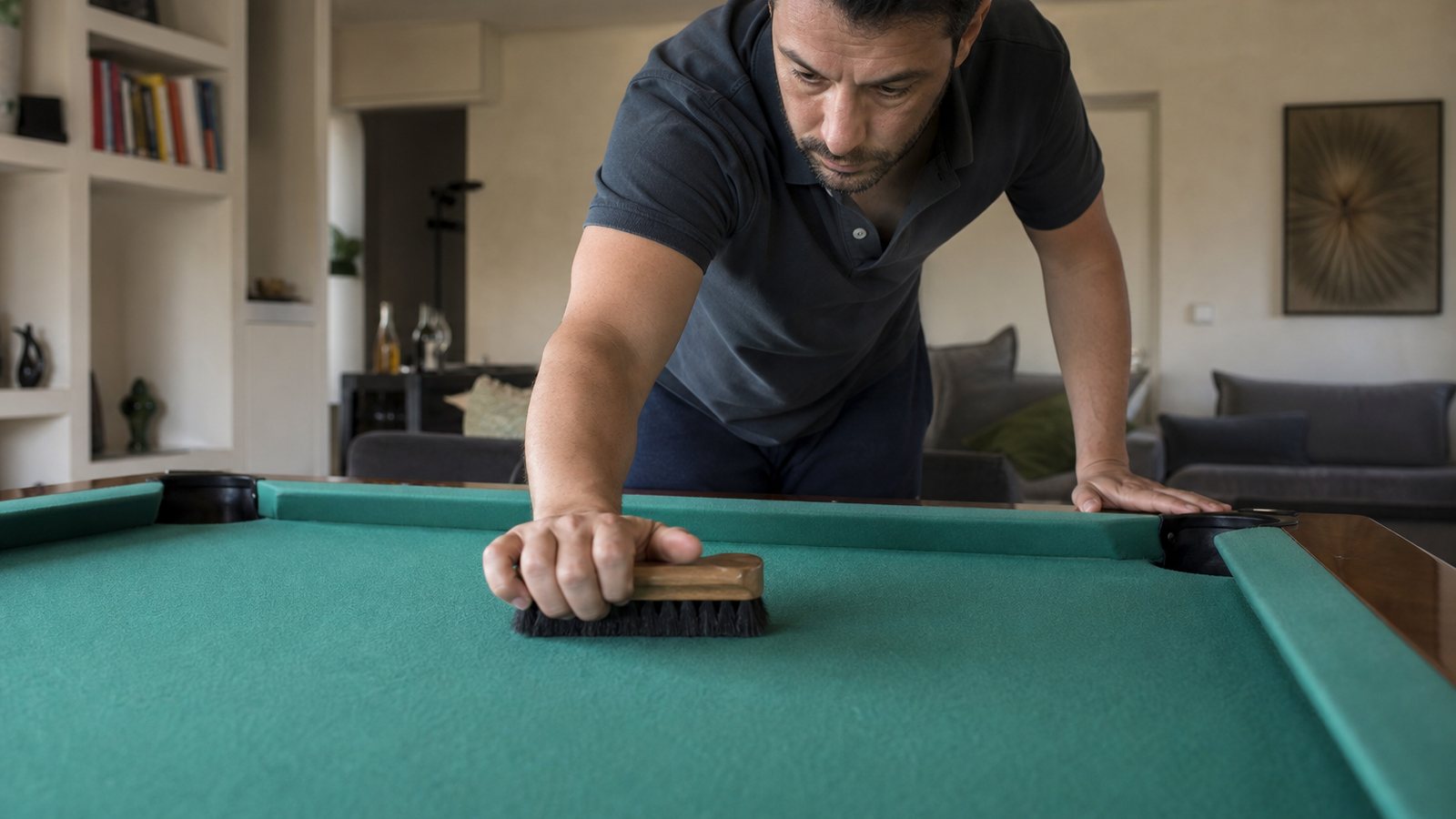 Mains brossant avec soin le tapis vert d'un billard dans le sens du drap